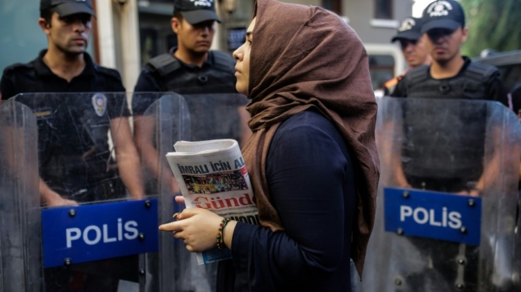 شابة تحمل نسخة من صحيفة "اوزغور غونديم" امام عناصر شرطة مكافحة الشغب في اسطنبول، 16 اب/اغسطس 2016